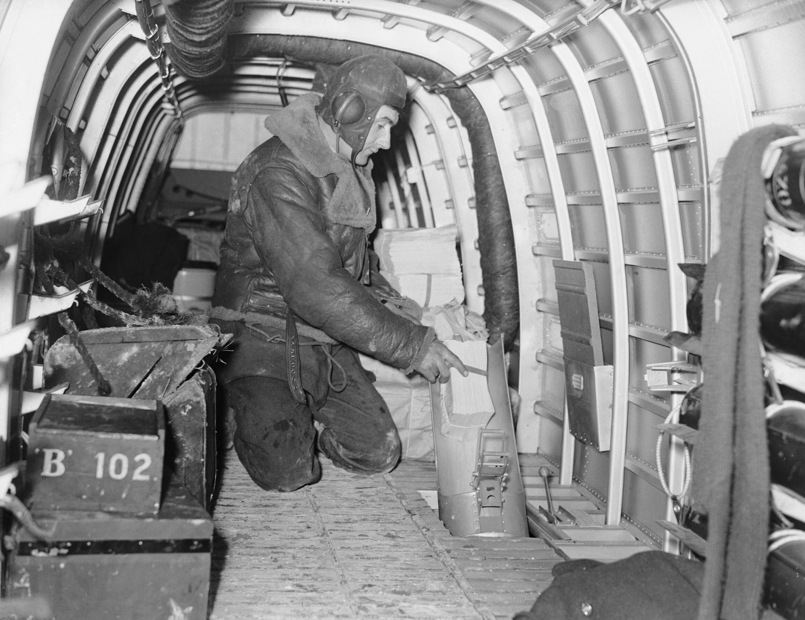 An RAF airman feeds propaganda leaflets into the flare chute of a Whitley bomber before a 'Nickel' leaflet raid, France, 1939-41. Photo: H. Hensser, Royal Air Force official photographer (IWM C 826), Public domain, via Wikimedia Commons